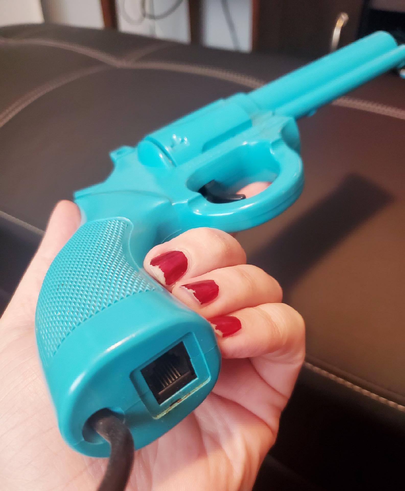 My hand holding the Konami Justifier lightgun, showing the phone jack on the bottom My hand holding the Konami Justifier lightgun, showing the phone jack on the bottom