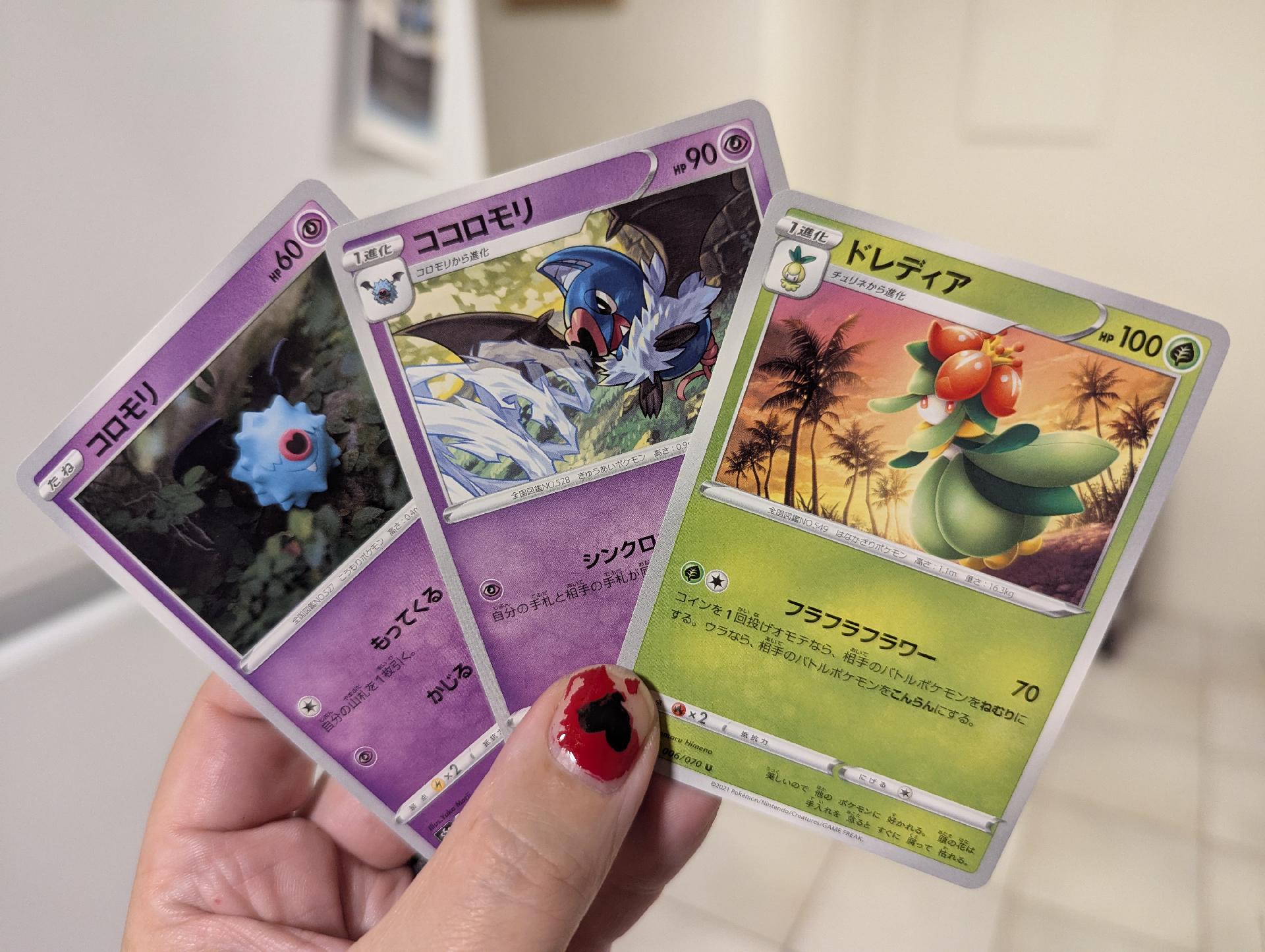 Three Pokemon cards, text is in Japanese, I don't recognise the characters. Two purple cards, one green.