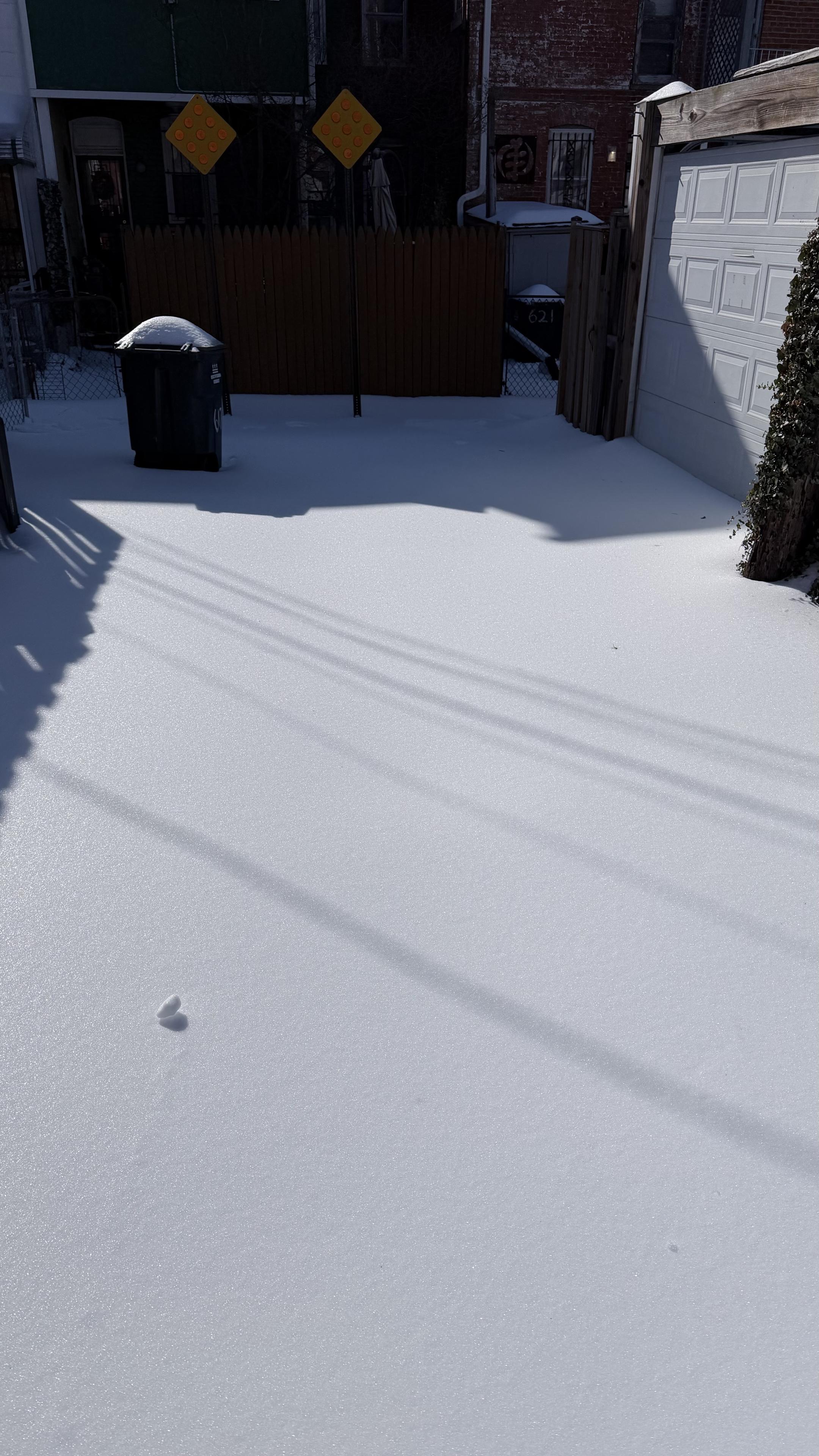 Photo of an alley covered in what looks like fresh snow but is actually 6-day old ice.