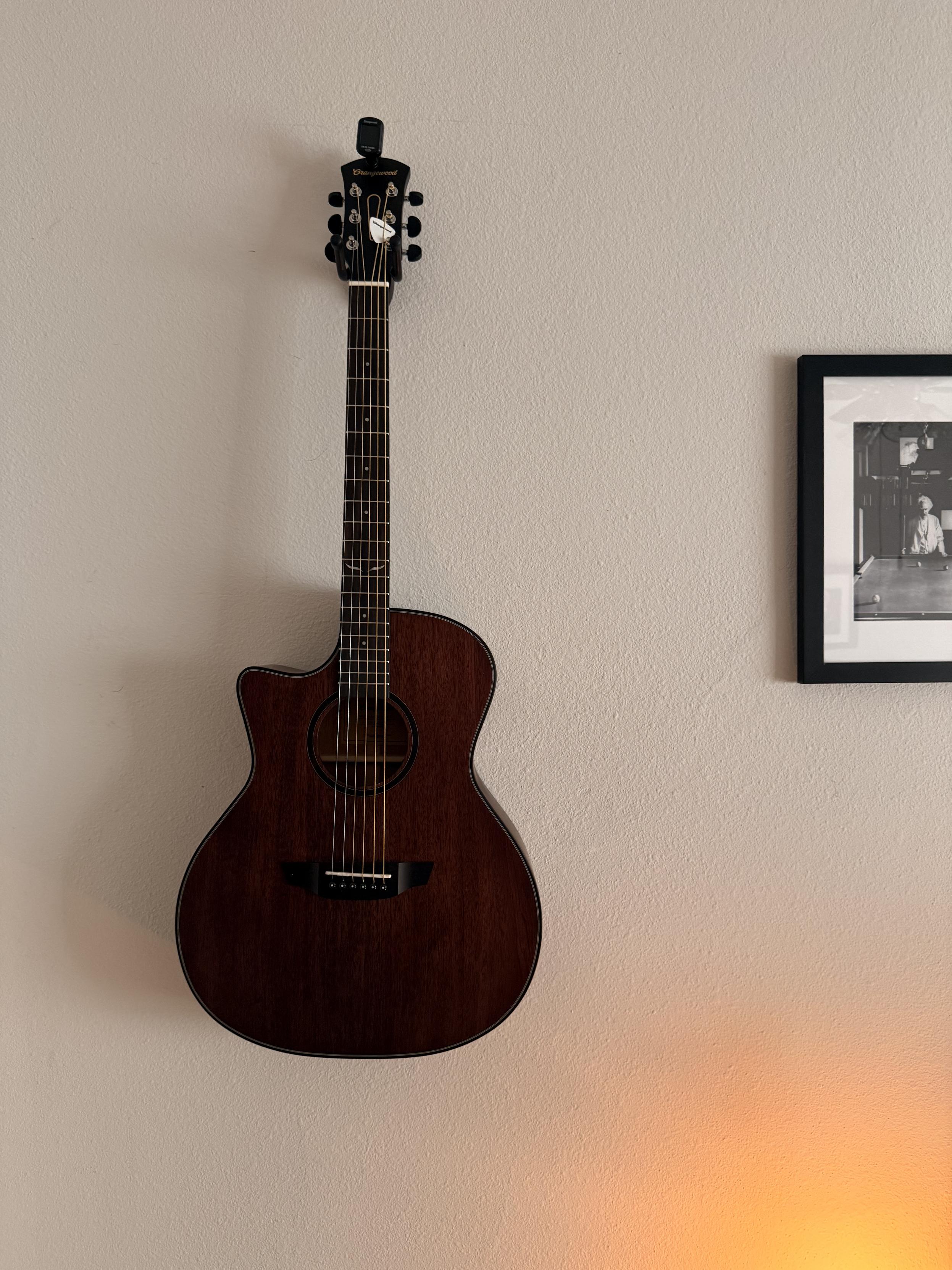 Mahogany left-handed guitar hanging on a wall.