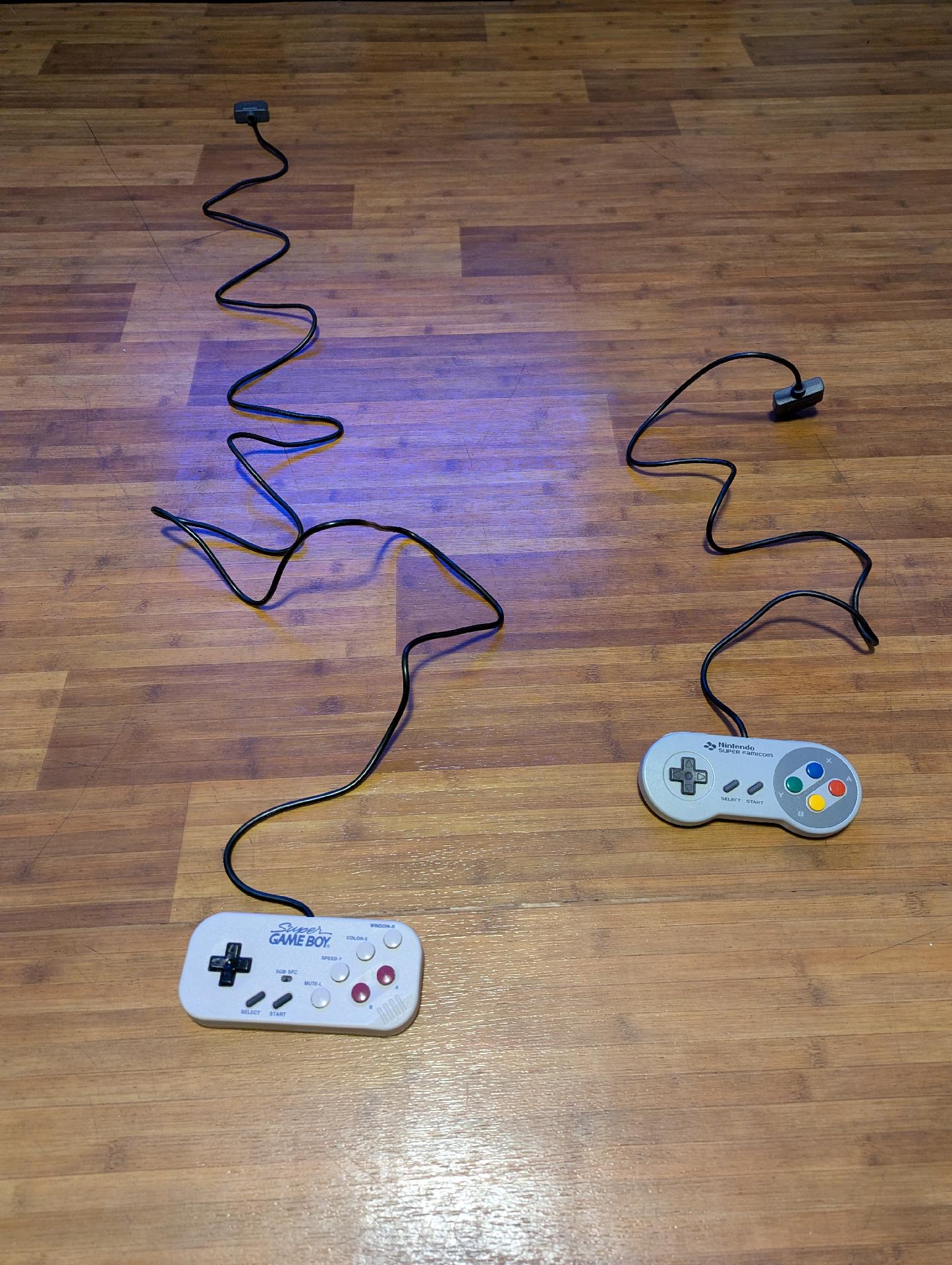 The SGB Commander controller with the original Super Famicom controller, side by side, showing the difference in cable length. The SGB Commander appears roughly 3x as long!