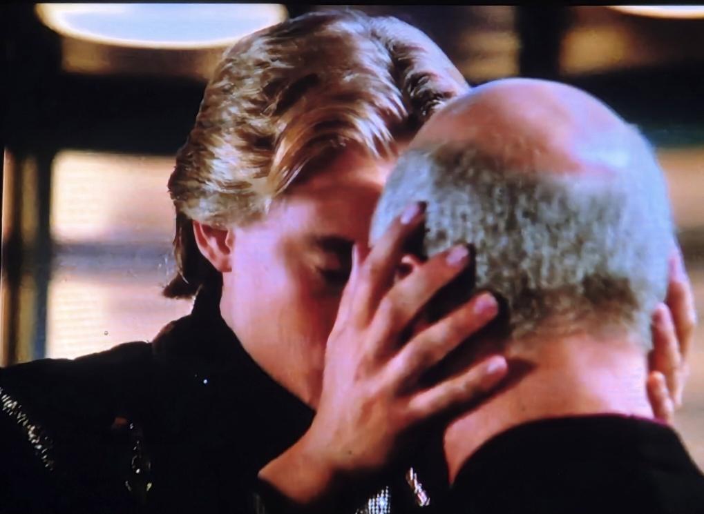 Chad Allen holding Captain Picard's head touches foreheads with him in a Talarian manner of affection. They are at a Transporter room and he is saying goodbye.