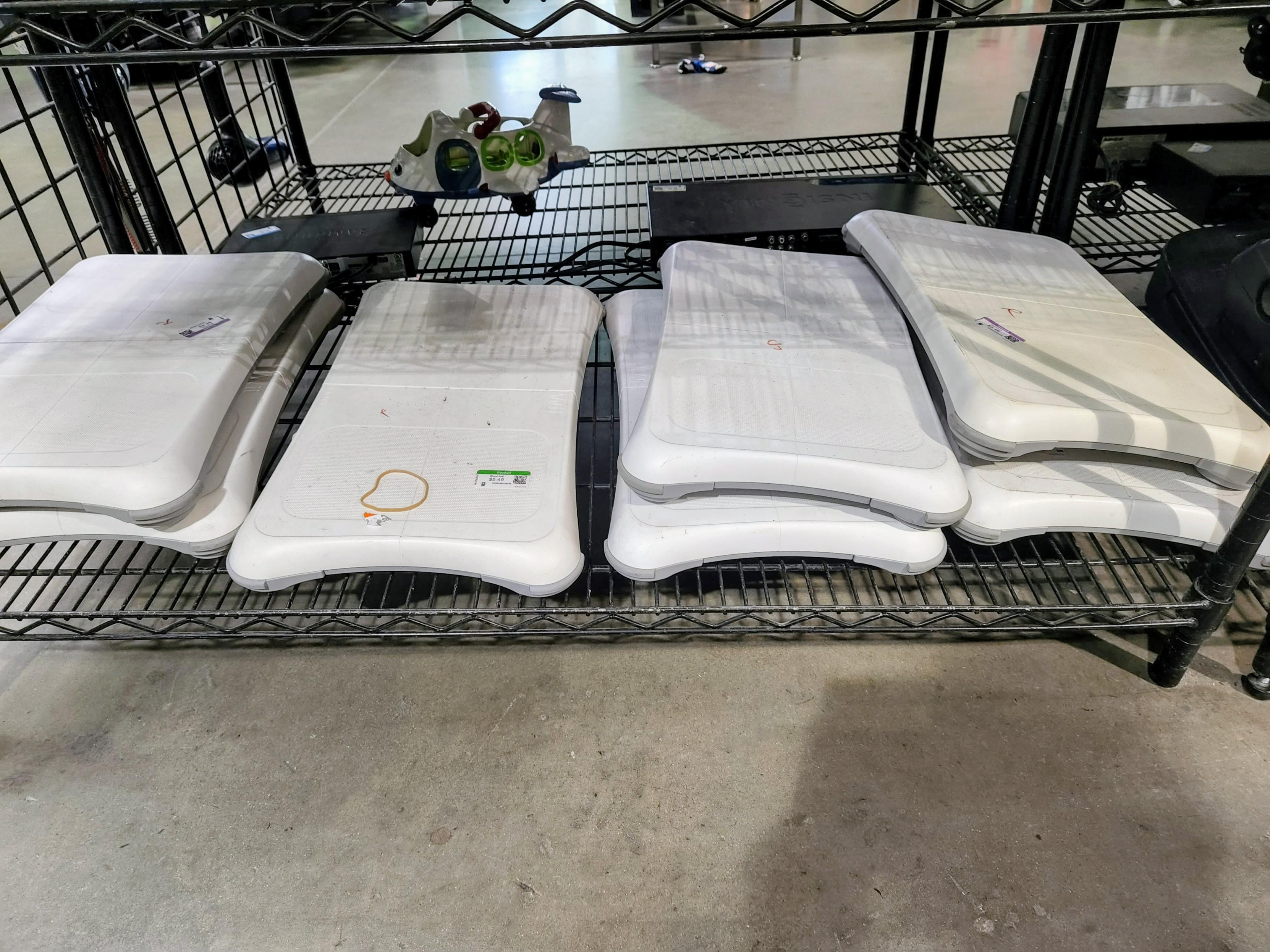 A shelf of seven Wii fit boards.