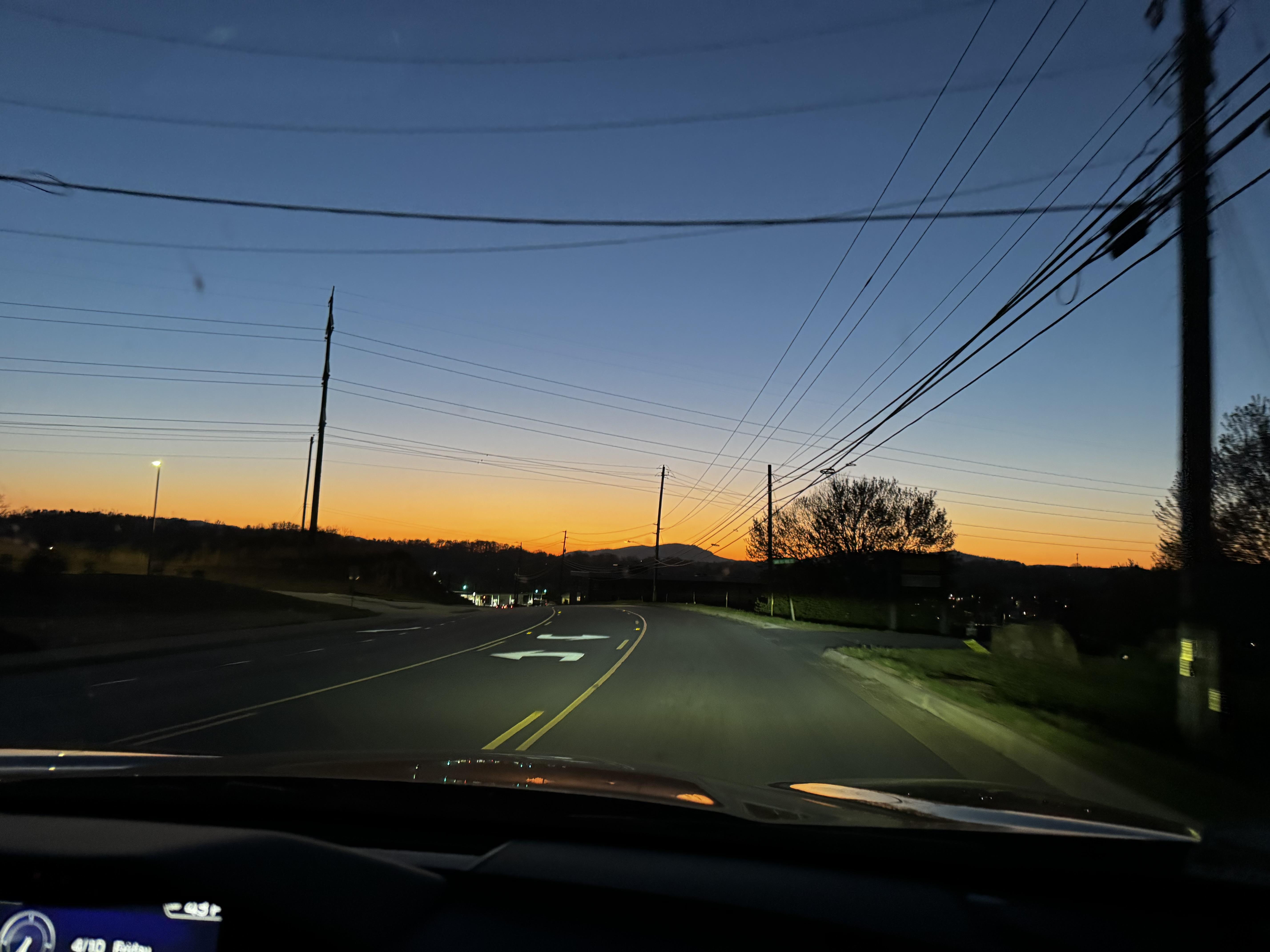 A very dry, cold morning here in Western North Carolina, and the sun is already painting a beautiful sky to the east.  The gorgeous blue shading down through pinks to yellow and orange at the horizon.  About 6:30 and a half hour before dawn.  We're having to get up earlier and earlier to be out before the light.

This photo is from a car on a road, with many poles and wires, but if you just look at the sky it's quite pretty.