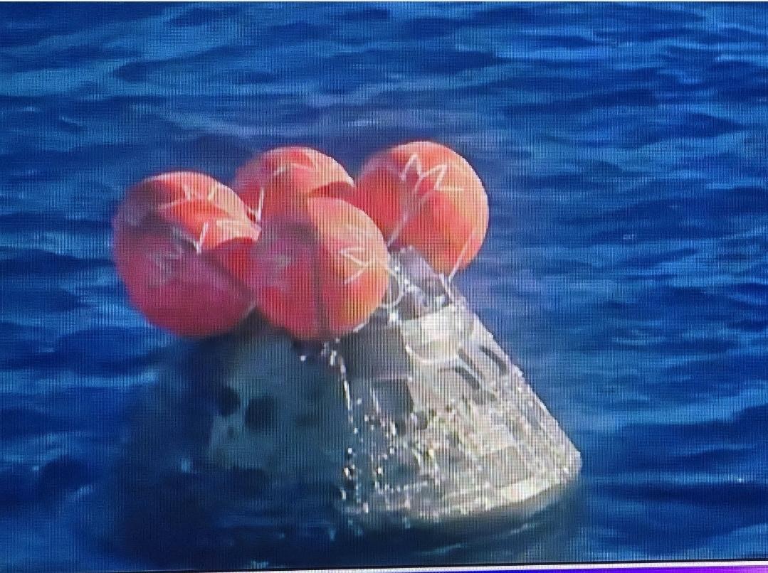 Up close picture of the capsule with 3 large red balloons on top.