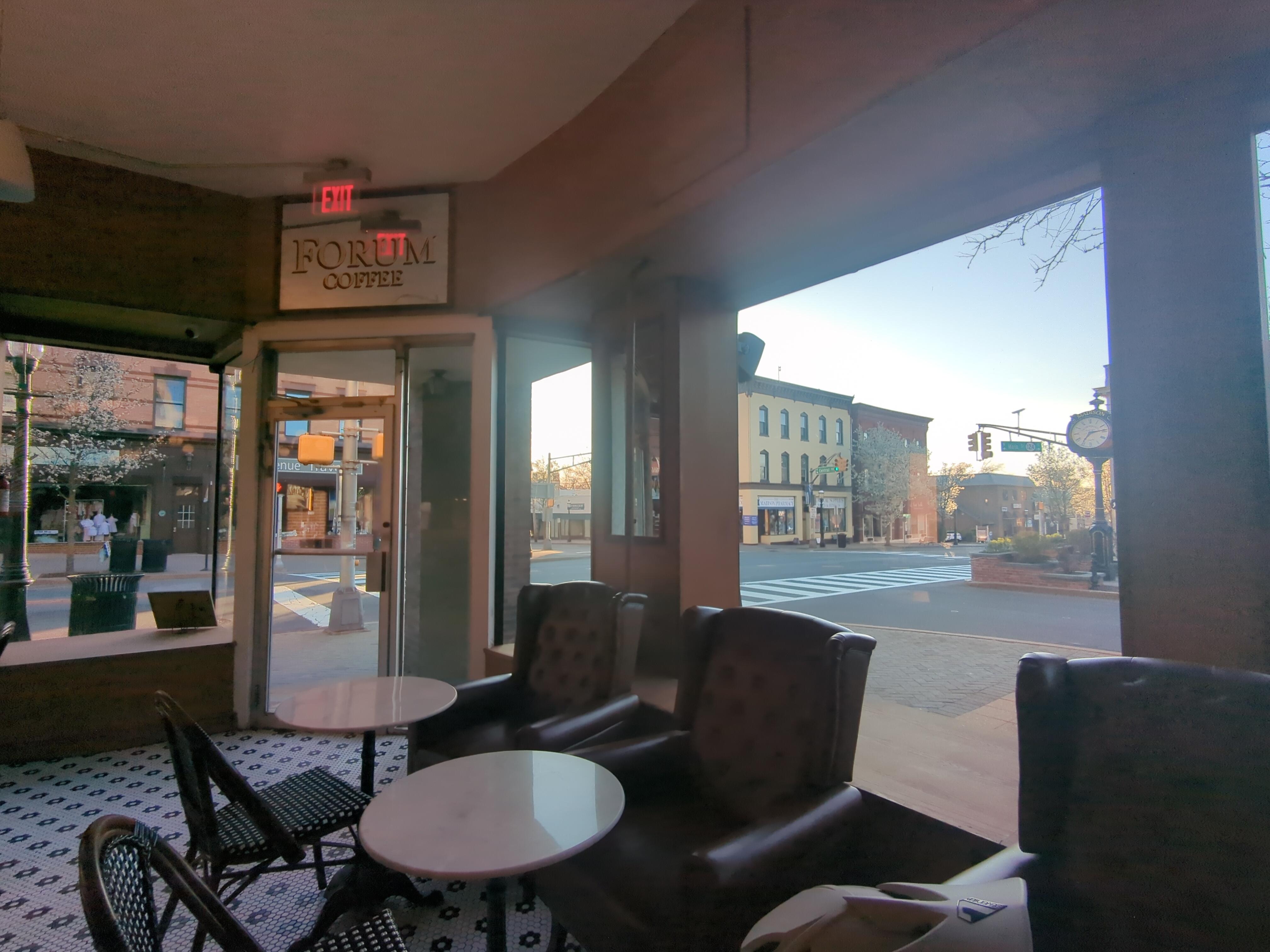 View from a table at Forum Coffee in Madison, NJ. Corner entry door is in view, as well as the town center and clock through the windows.