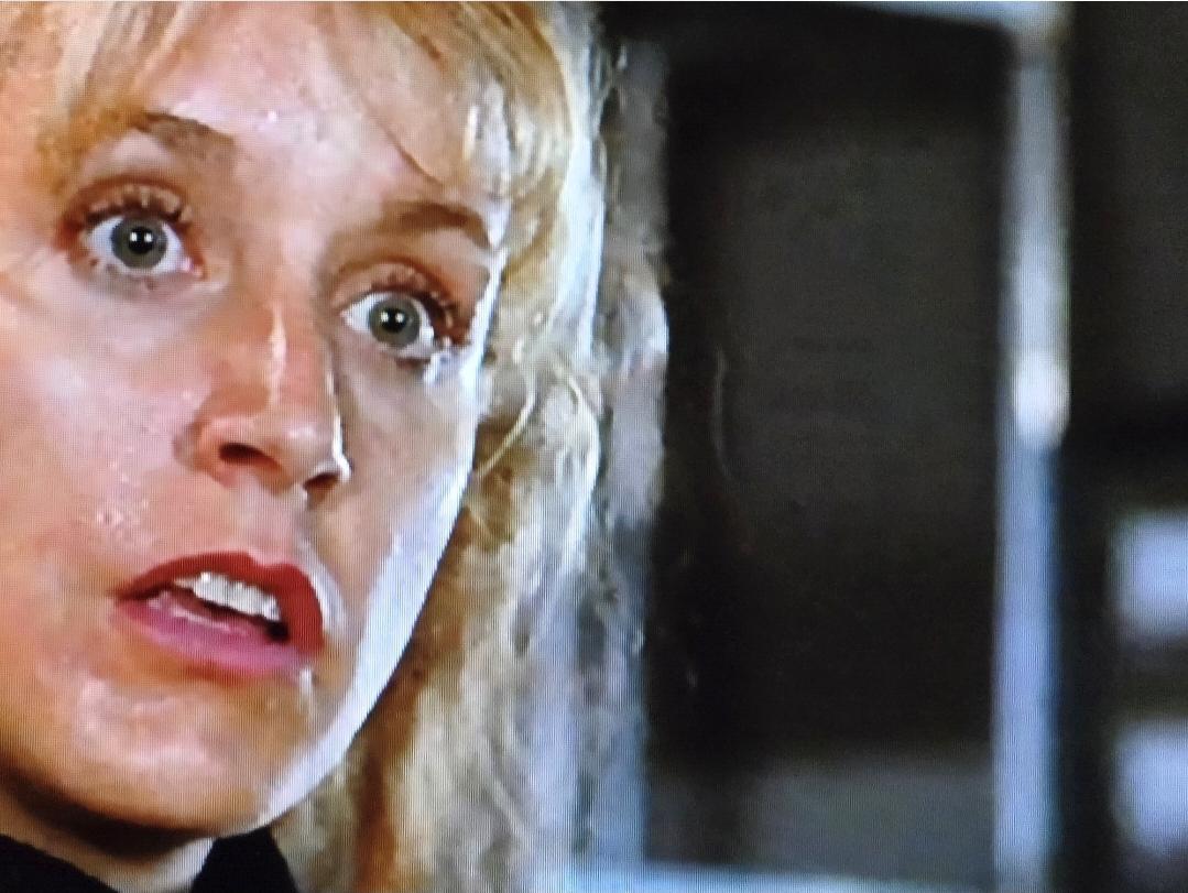 Felicity Huffman in her 20s looking surprised and sweaty.