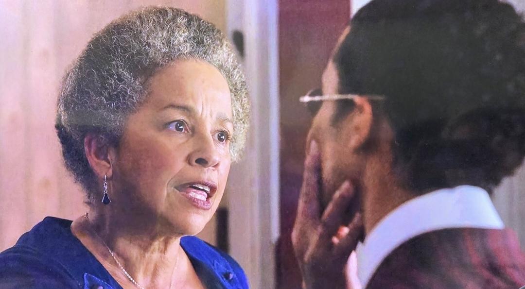 Rae Dawn Chong as Florence de Pointe du Lac. In this photo she is holding her son Louis' head ashe looks him in the eye and says "Ah, there he is." He has her hair back in a matronly bun and is finely dressed in elegant royal blue gown with simple black chandelier drop earrings. She is dressed ala mode for that time period.