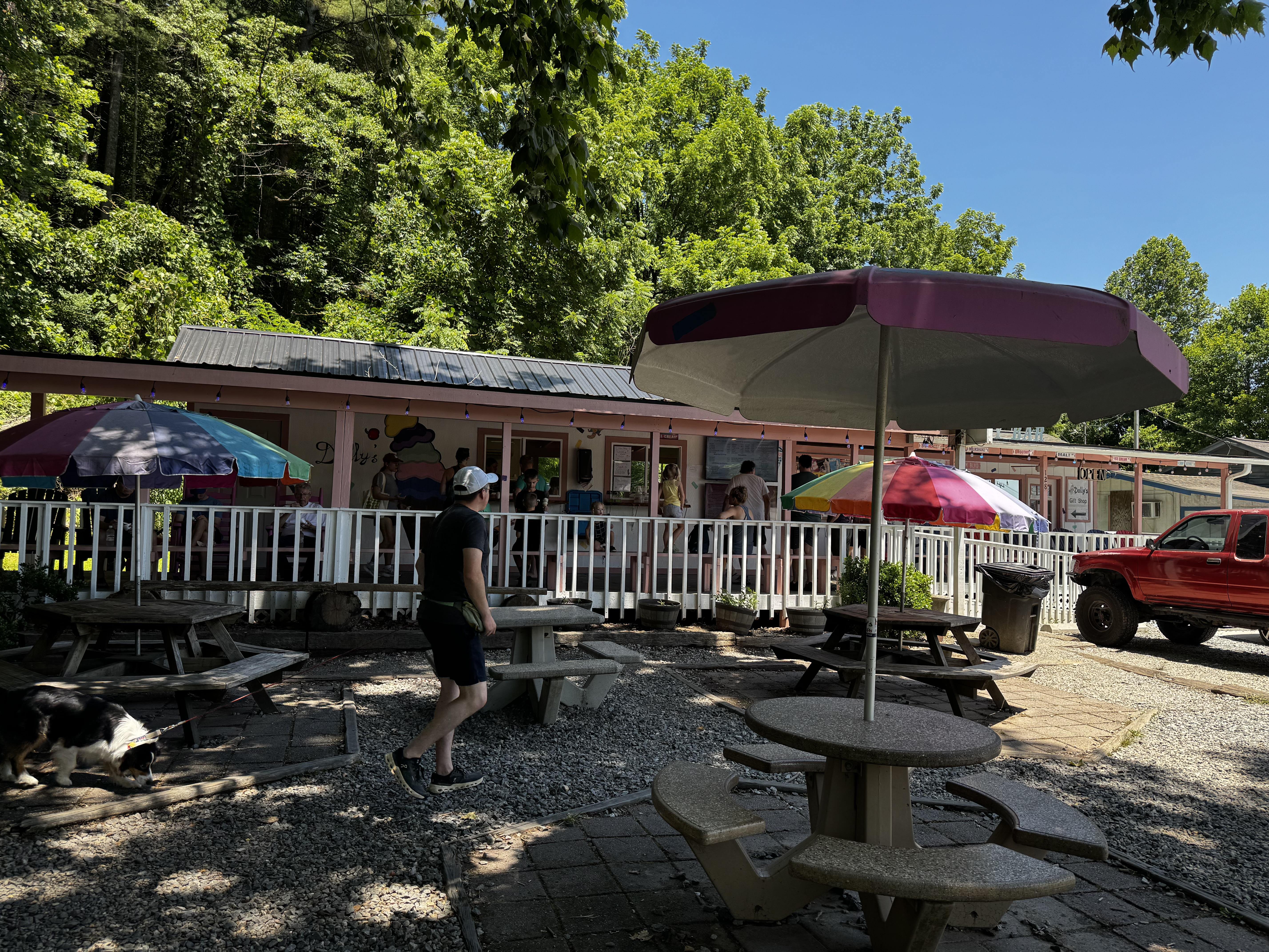 The long, low building looks a bit like an old motel, with a white railing at the edge of the covered porch, and 2 windows, where one orders and then picks up their treats.  Several picnic tables sit under huge trees, providing much-needed shade.

Today it was steady but not mobbed.